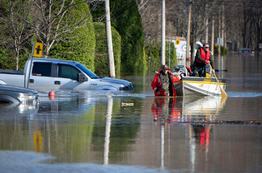 FOTO AFP-NA MONTREAL. Polic&iacute;as canadienses en un bote en una calle inundada en Sainte-Marthe-sur-le-Lac.