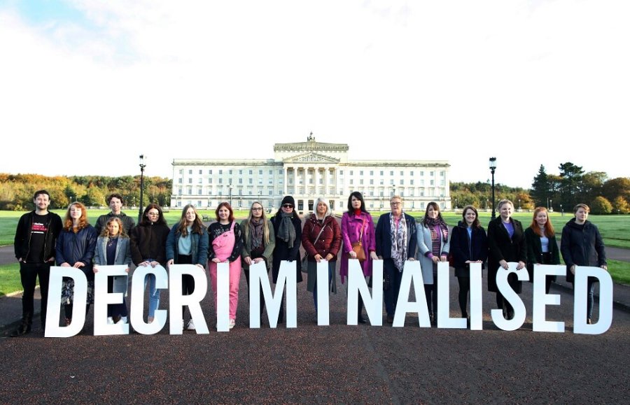 FOTO AFP CAMBIO. Partidarios proabortistas posan con un cartel que dice "descriminalizado" al frente de los edificios del Parlamento en Belfast.