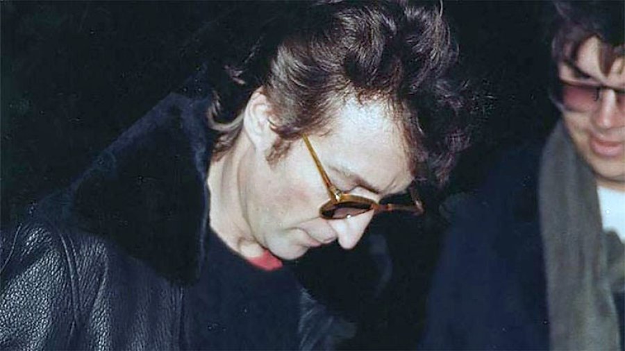 FIRMA. Lennon autograf&iacute;a el disco a Chapman.