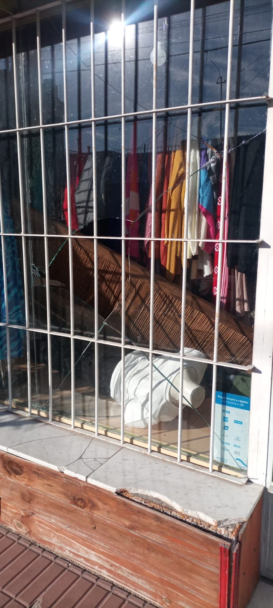 Con el vidrio roto y a través de las rejas se las ingeniaron para saquear la vidriera del negocio.