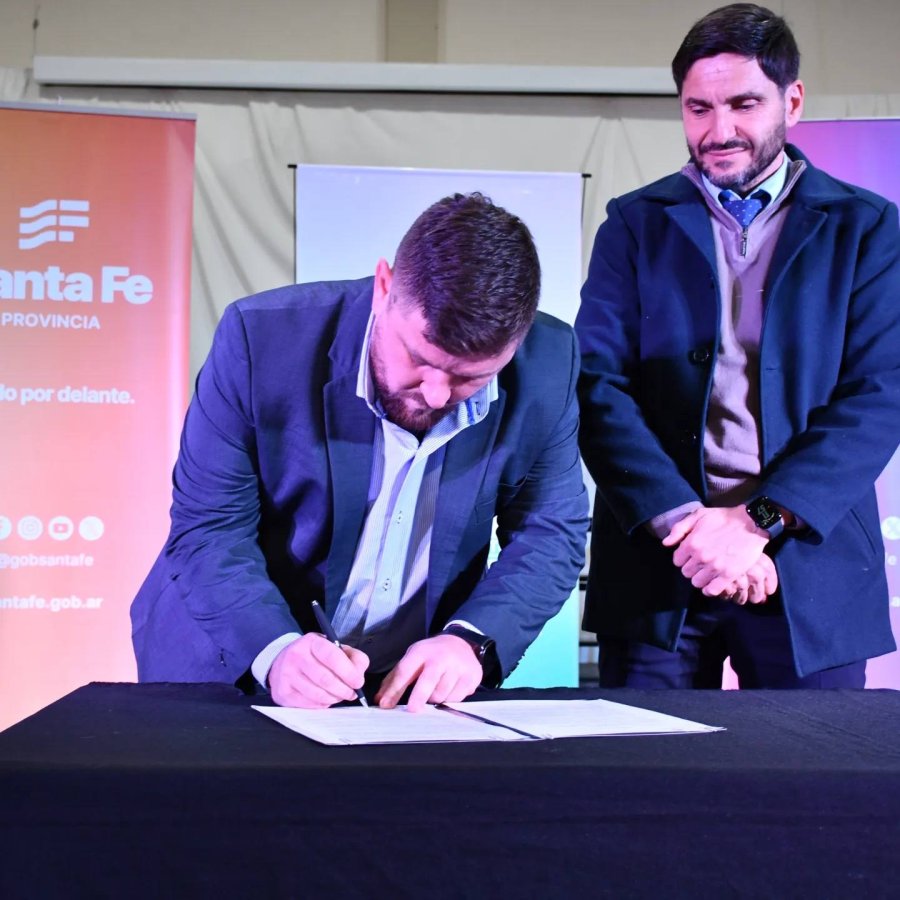 Pablo Pinotti firma, observa Maximiliano Pullaro.