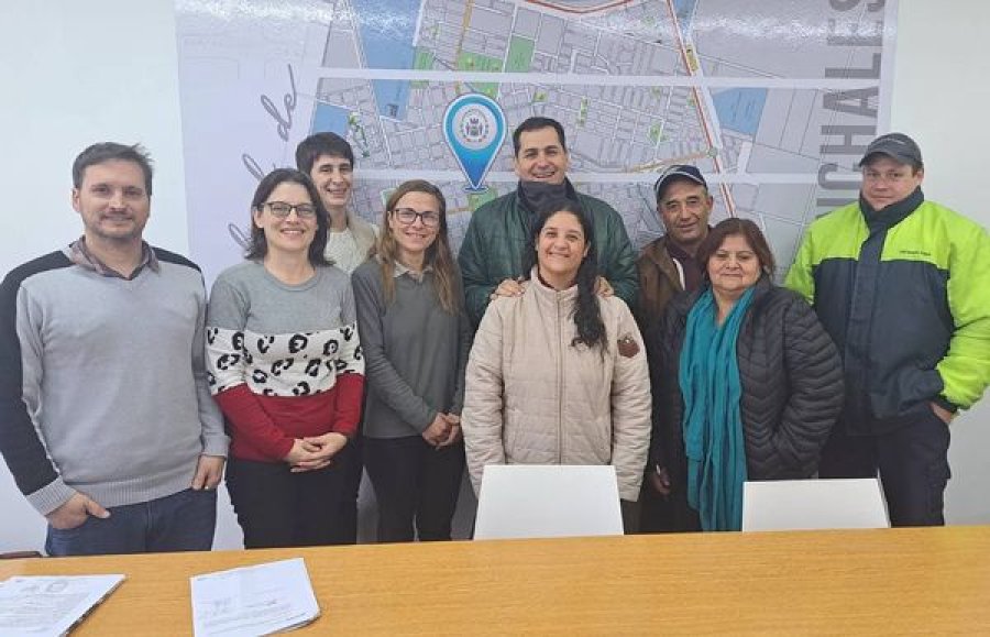 Funcionarios y beneficiarios en el acto de firma.