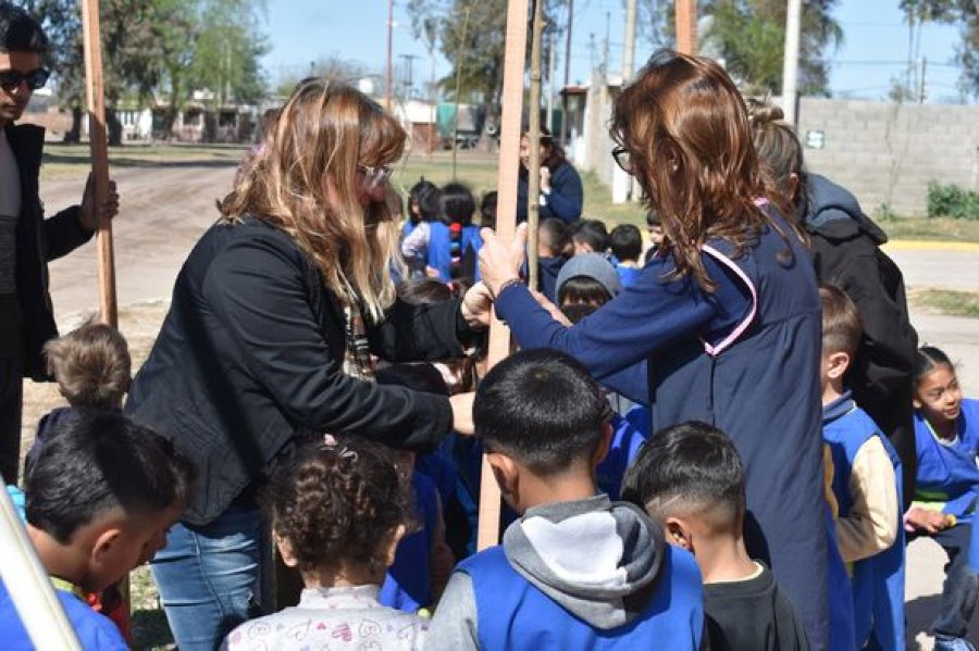 Docentes y alumnos plantando un ejemplar.