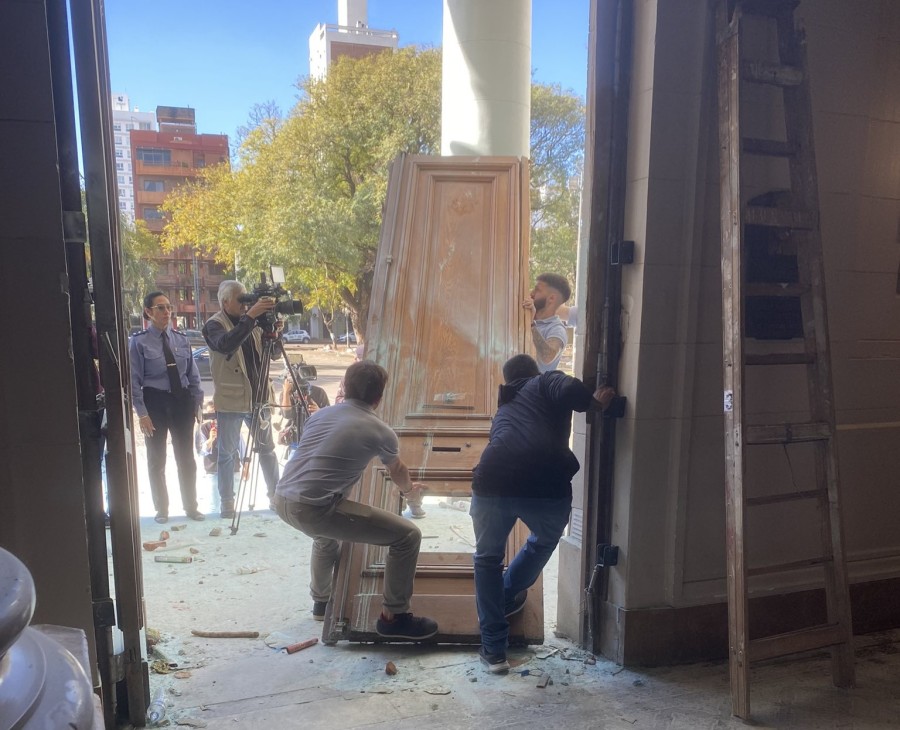 DA&Ntilde;OS. Empleados de la Legislatura tratan de levantar una de las hojas de la puerta principal de la Legislatura.