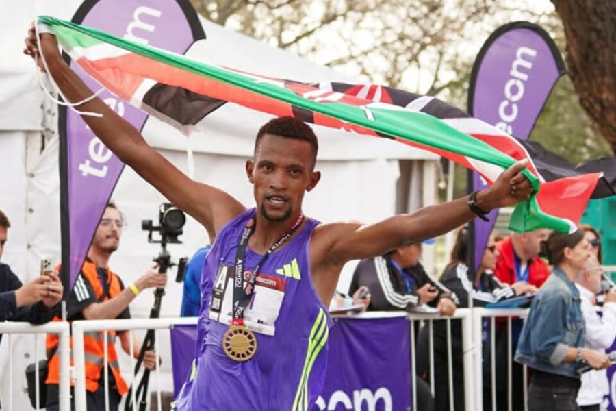 Bethwell Yegon alza las manos con la medalal y la bandera de Kenia.