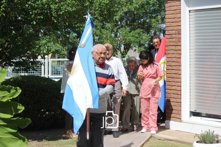 Residentes portando el pabell&oacute;n nacional para presidir la ceremonia celebratoria.