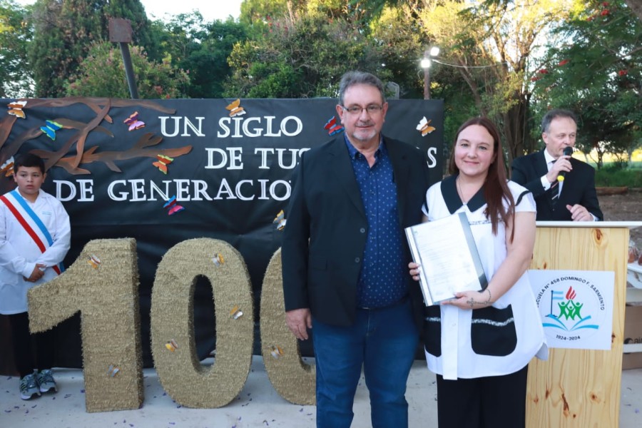 Pedro Fraire, titulasr de la Comuna y exalumno entrega el reconocimiento a la directora, Ivana Grazziotto.