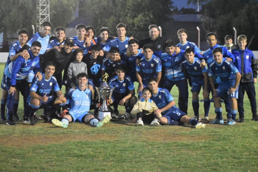CON EL TROFEO. El plantel en la cancha de Ferro.