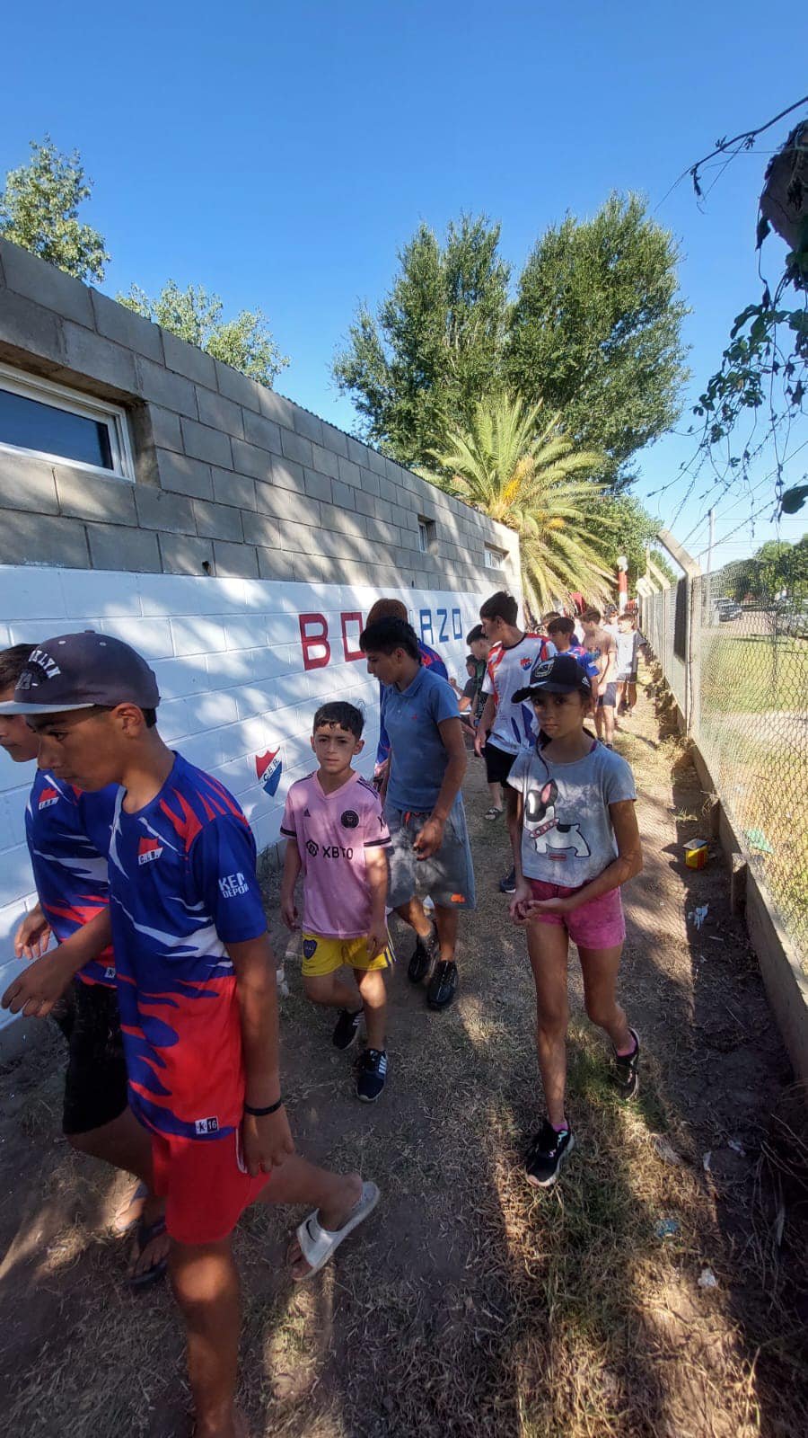 Un grupo de niños frente al mural elaborado.