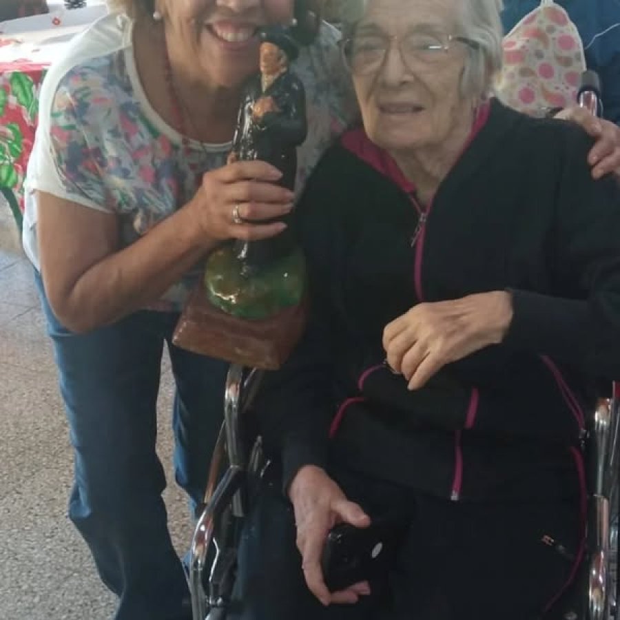 VISITA. Una de las integrantes del grupo con la imagen del Santo y una residente.