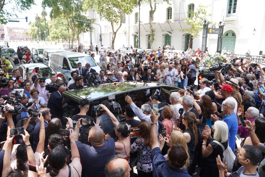 Una importante cantidad de personas rodea el auto que traslada los restos del periodista Jorge Lanata en el inicio del cortejo rumbo al Cementerio de Florencio Varela.