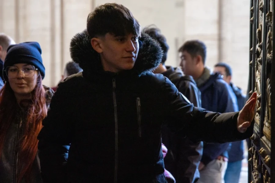 Peregrinos cruzan la Puerta Santa de la Basílica de San Pedro en el Vaticano.
