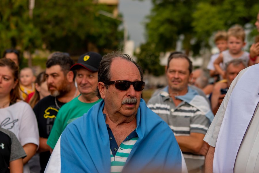 A pura emoción, Owen Crippa envuelto en una bandera argentina entre el público que se acercó a apreciar el paso del Aermacchi.