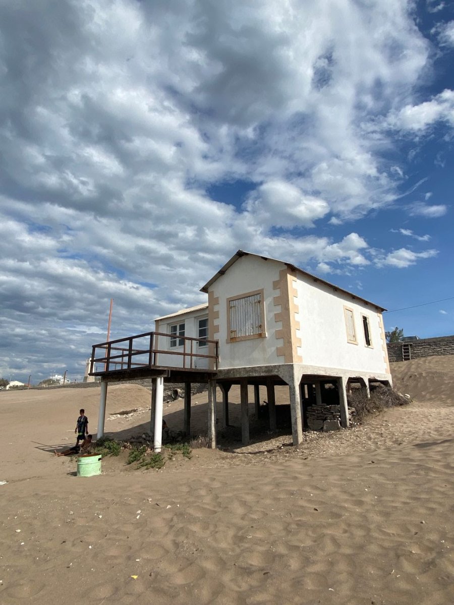 Su fachada solitaria, desgastada por la sal y el agua y sus cimientos enterrados en la arena, narran una historia que la empodera: la de sobrevivir contra todo pronóstico.