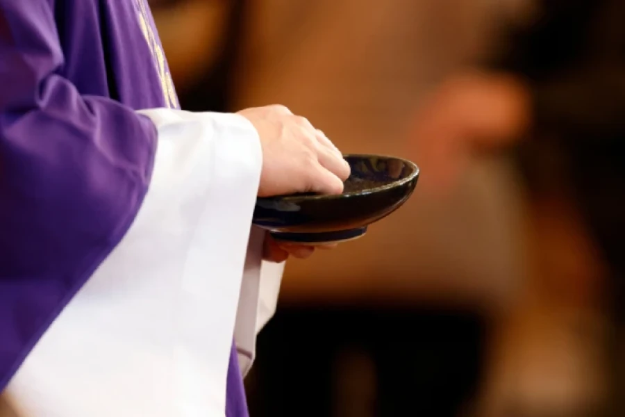 Sacerdote participando de la imposición de cenizas.
