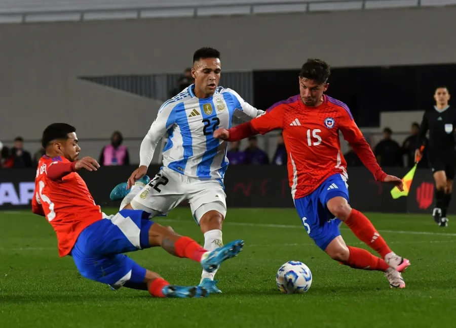 El delantero argentino Lautaro Martínez disputa la pelota ante el chileno Felipe Loyola de Independiente y el defensor Paulo Díaz de River.