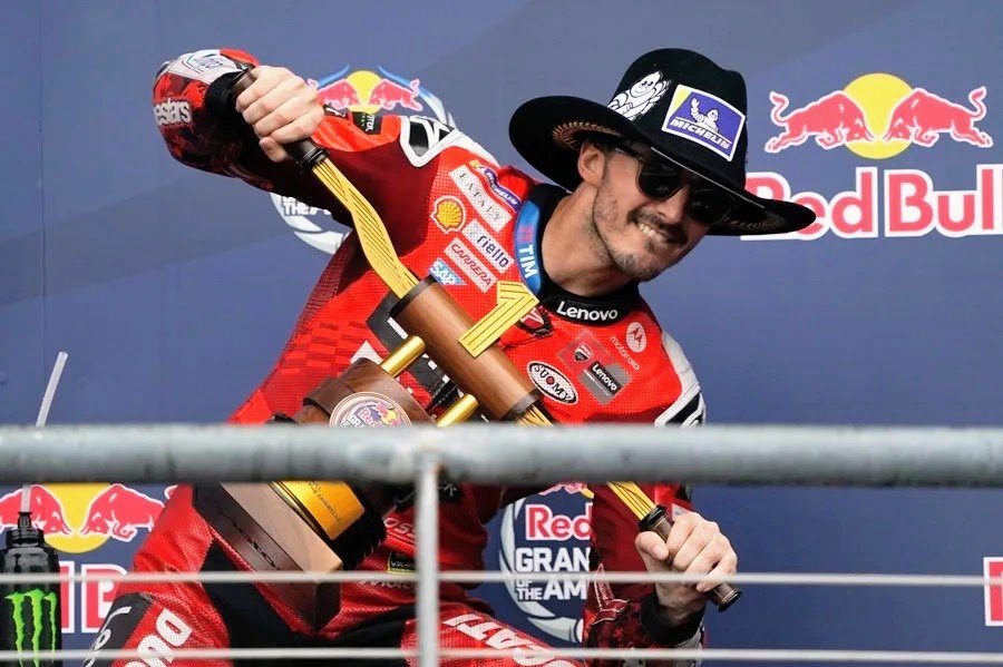 Francesco Bagnaia con el sombrero tejano y el trofeo en el podio de Austin.