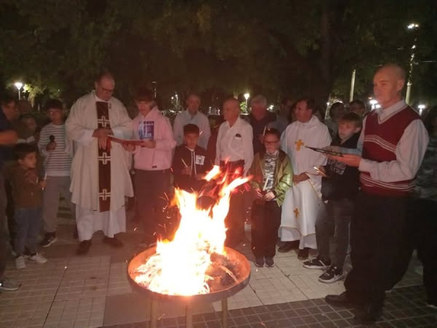 El párroco Fernando Sepertino, el padre David Retamoso y fieles durante la liturgia de la luz.
