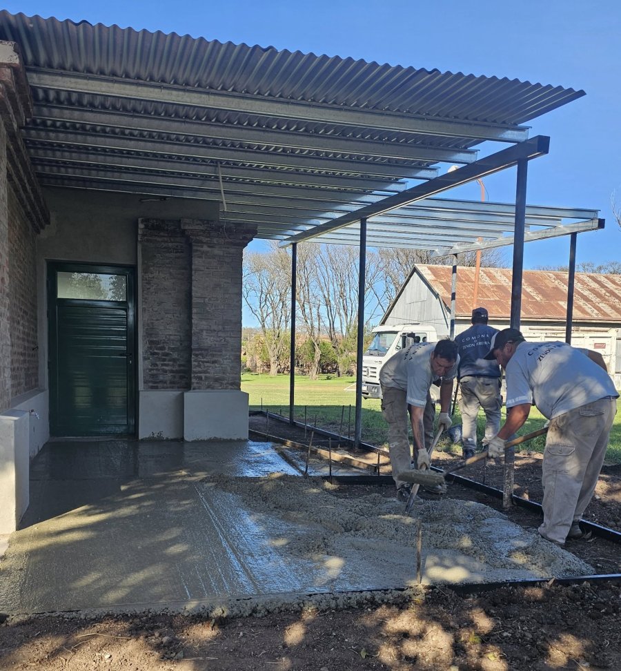 Cuadrilla comunal laborando en la vereda del espacio cultural.