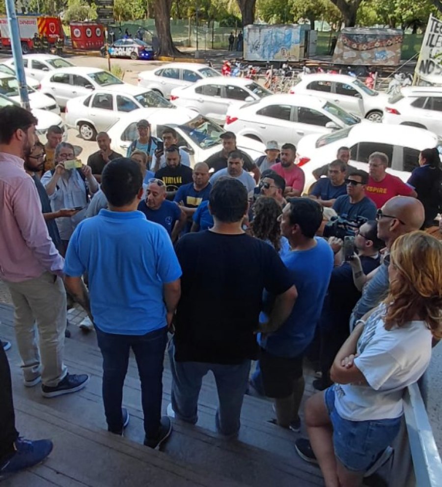 TENSIÓN. Los remiseros en las escalinatas del edificio municipal dialogan con un funcionario del Concejo.