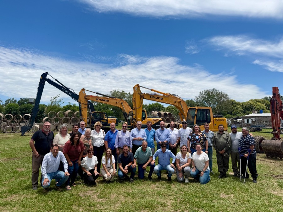 Los participantes junto a la retroexcavadora.