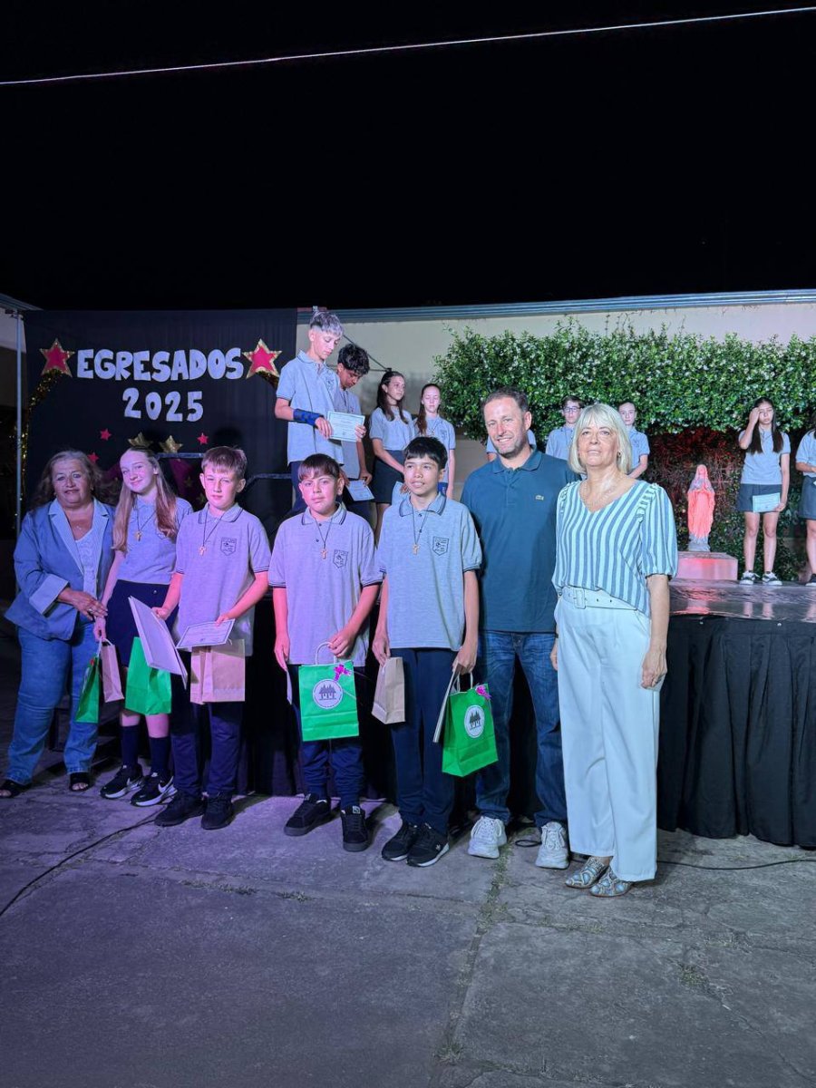 Los alumnos distinguidos junto a representantes comunales, detr&aacute;s todo el grupo de egresados.