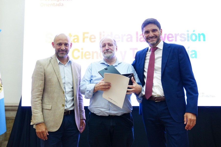 El ministro Puccini y el gobernador Pullaro al entregar el certificado al representante de una de las instituciones beneficiadas. (FOTO SCS)