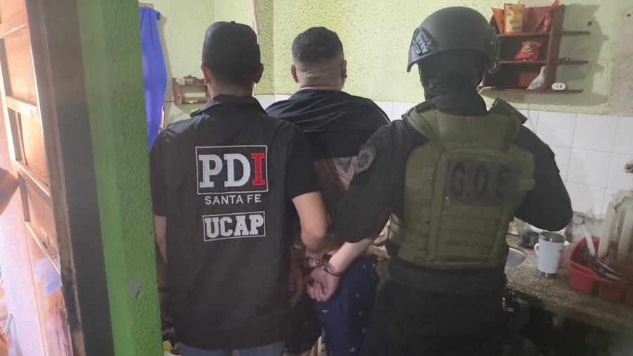 Dos agentes de la PDI custodian a Mendieta tras su captura.