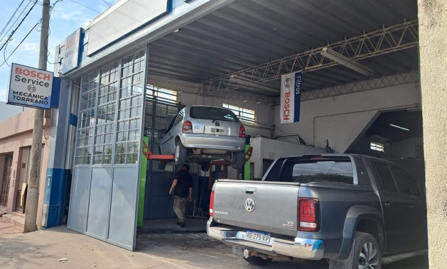 El taller en funcionamiento a pleno, con uno de los veh&iacute;culos sobre el elevador. (FOTO MT)