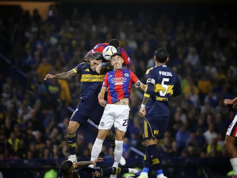 El colombiano Roma&ntilde;a cabecea la pelota ante la presencia de su compa&ntilde;ero Gast&oacute;n Hern&aacute;ndez y el rival Lautaro Di Lollo.