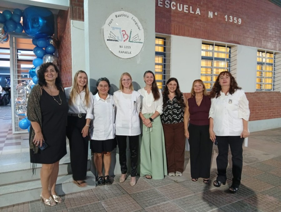Las autoridades junto al logo de la escuela.