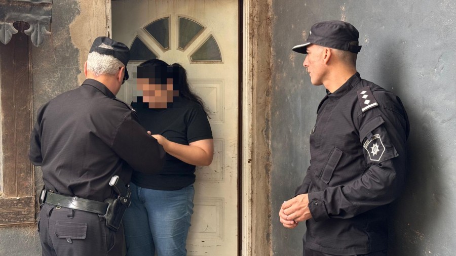 Efectivos policiales entregan una notificaci&oacute;n en la casa de uno de los responsables de amenazas a escuelas santafesinas.