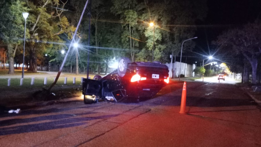 El veh&iacute;culo con sus ruedas hacia arriba frente al Parque Balneario Municipal en la madrugada de este domingo.