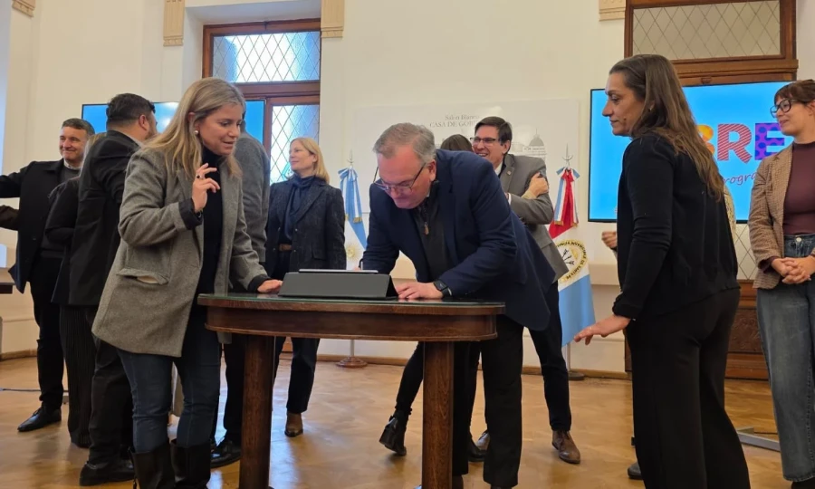 Felipe Michlig firma uno de los convenios.